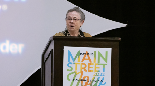 A woman speaks from behind a podium.