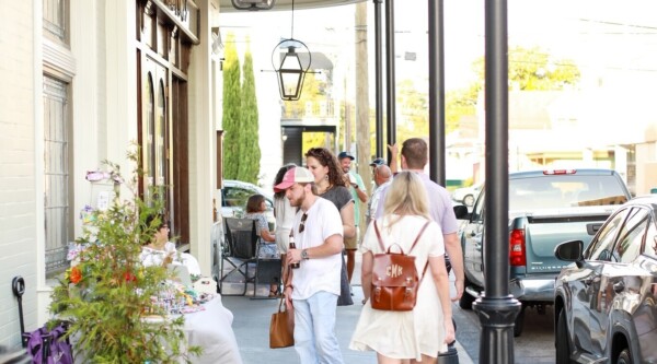 People walk under historic balconies in downtown Thibodaux, LA