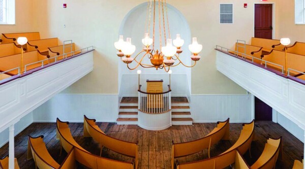 View from the balcony of the African American Meeting House in Boston, Massachusetts showing wood pews facing a front podium.