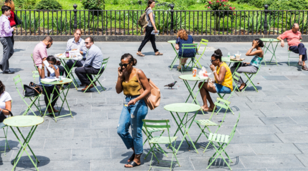 People sitting at tables at an outdoor downtown patio