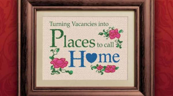 A graphic that looks like old cross-stitch art and reads "turning vacancies into places to call home"