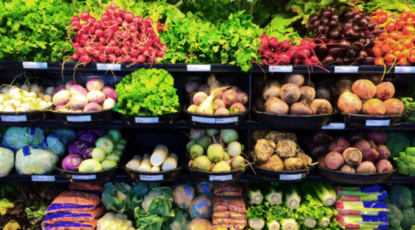 Shelves of cold produce in a small grocery store