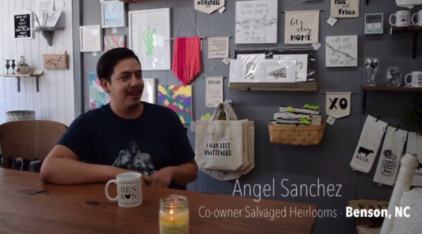 Business owner sits at counter smiling