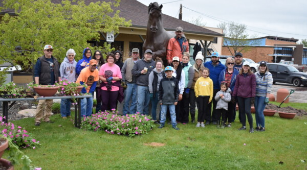 A group photo of the volunteers who helped transplant and hang over 225 flower baskets on the historic street lamps on Main Street