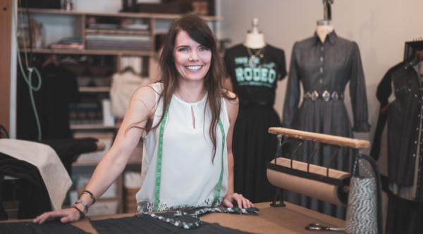 A woman stands at a tailoring workbench