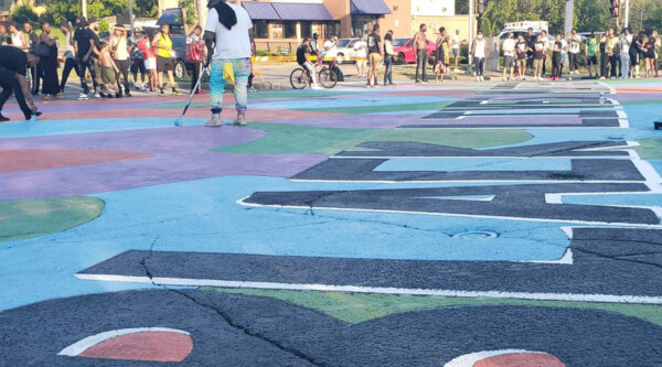 A person painting a mural for Black Lives Matter