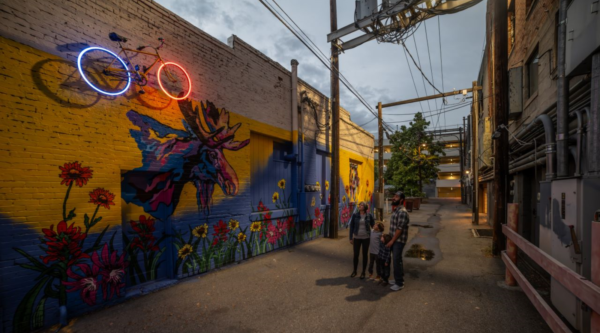 Neon bicycle art in an alleyway