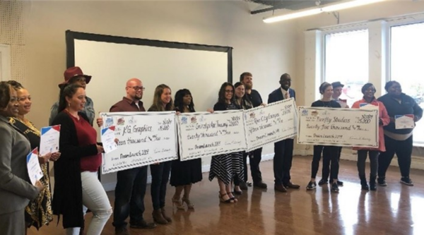 Economic vitality boot camp participants holding large award checks